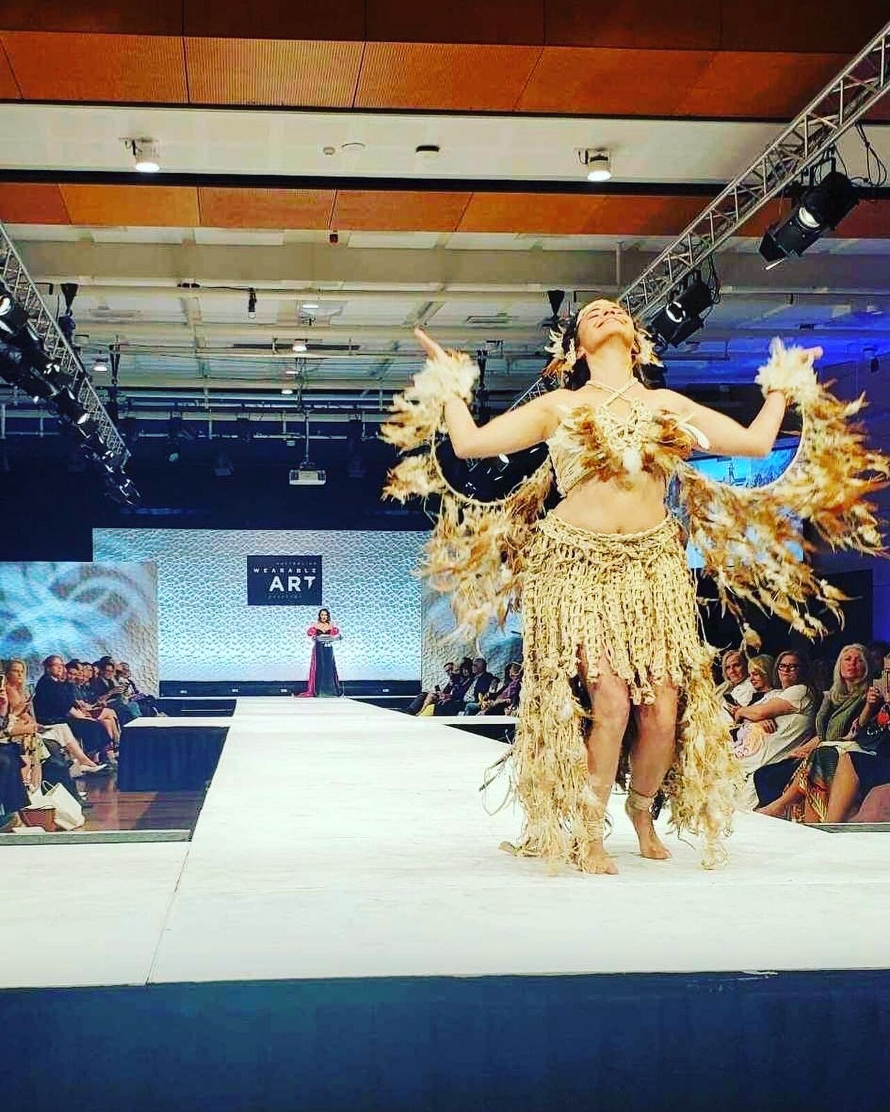 Alpha on the runway in a feathered wearable art costume