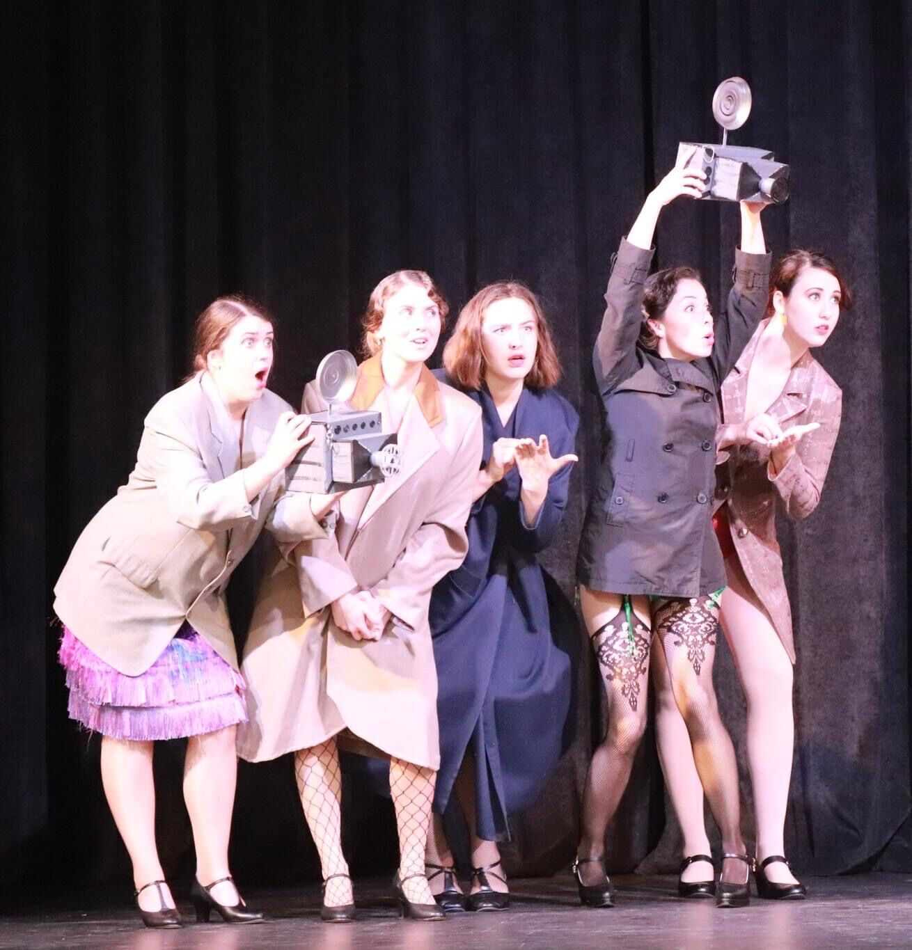 Performers on stage with an old camera