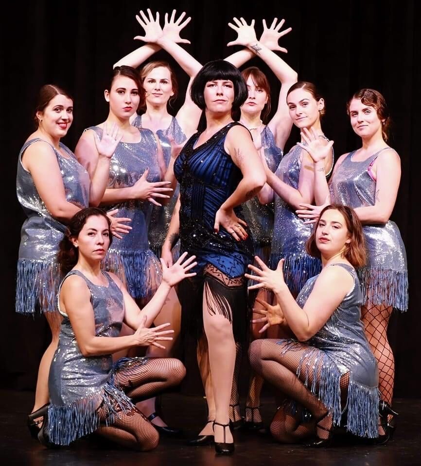 A theatre cast posing in flapper costumes