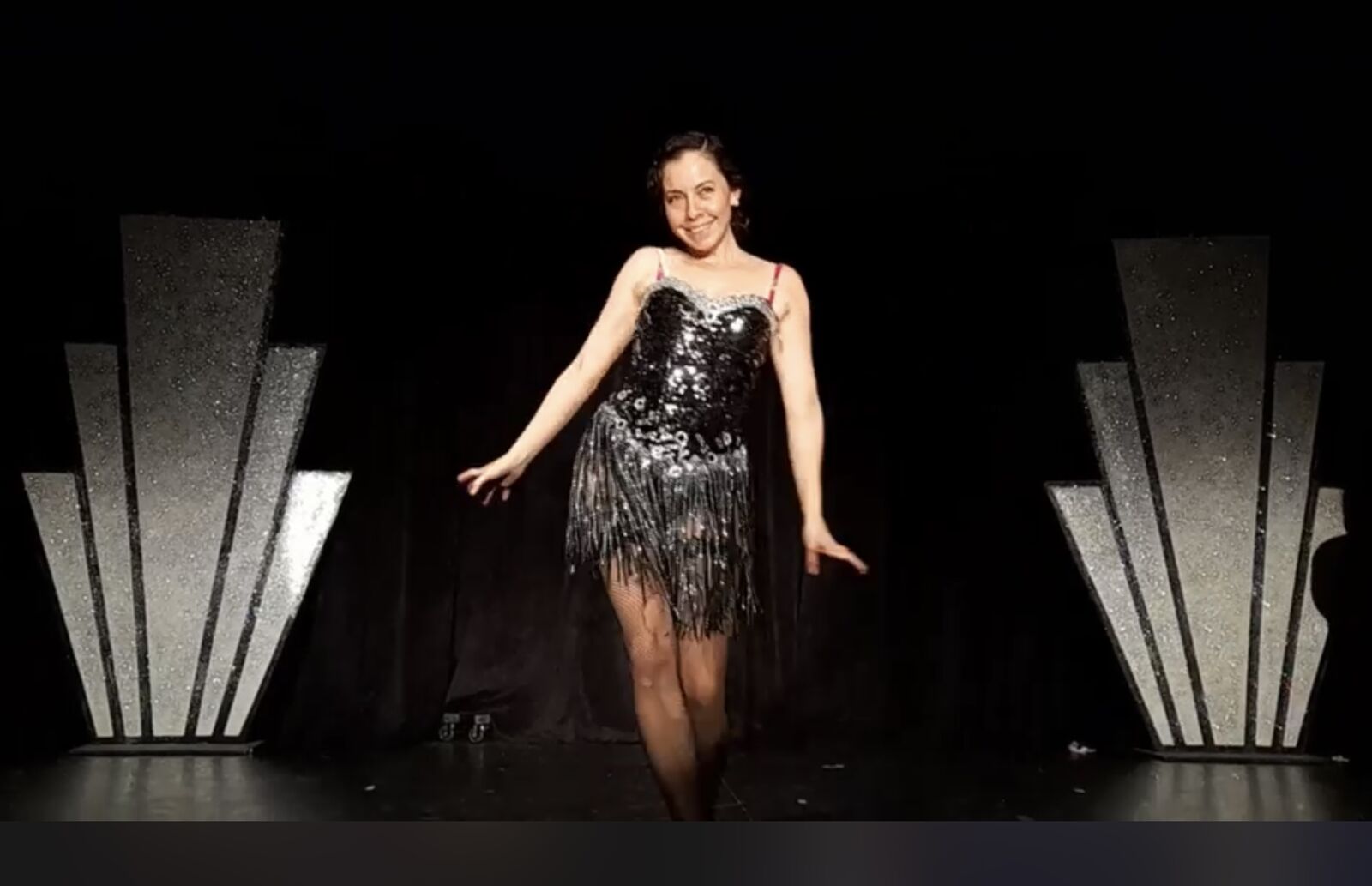 Alpha on stage in a sequin flapper dress